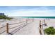A scenic beach walkway with a rope fence leads to soft sand and inviting ocean waters at 1935 Gulf Of Mexico Dr # G7-304, Longboat Key, FL 34228