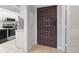 View of the front door and galley kitchen featuring granite countertops and black appliances at 1935 Gulf Of Mexico Dr # G7-304, Longboat Key, FL 34228