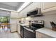 Well-lit kitchen features white cabinets, granite countertops, tile backsplash and black appliances at 1935 Gulf Of Mexico Dr # G7-304, Longboat Key, FL 34228