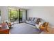 Bright living room leading to a screened balcony, furnished with modern seating and a dining table at 1935 Gulf Of Mexico Dr # G7-304, Longboat Key, FL 34228