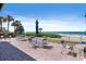 Outdoor patio area with tables, chairs, and umbrellas offers an ideal spot to enjoy meals by the beach at 1935 Gulf Of Mexico Dr # G7-304, Longboat Key, FL 34228