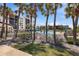 Community pool area surrounded by palm trees, fencing, and lush landscaping at 1935 Gulf Of Mexico Dr # G7-304, Longboat Key, FL 34228