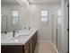 Bathroom featuring dual sink vanity, glass-enclosed shower, and white tiled walls at 2477 Water Willow Dr, Lutz, FL 33558
