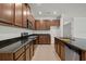Kitchen featuring a stainless steel dishwasher, dark wood cabinets, countertops and tile flooring at 2477 Water Willow Dr, Lutz, FL 33558