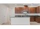 Kitchen with an island, stainless steel appliances, dark countertops, and wooden cabinets at 2477 Water Willow Dr, Lutz, FL 33558