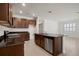 Spacious kitchen featuring an island, stainless steel dishwasher, and dark wood cabinets at 2477 Water Willow Dr, Lutz, FL 33558