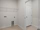 Functional laundry room with tile floors and wire shelving for storage solutions at 2477 Water Willow Dr, Lutz, FL 33558