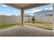 A covered patio featuring brick pavers and a fenced yard, perfect for outdoor living and entertaining at 2477 Water Willow Dr, Lutz, FL 33558