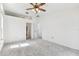 Well-lit bedroom boasts a neutral carpet, ceiling fan, and an open doorway to the attached bath at 254 Timberview Dr, Safety Harbor, FL 34695