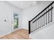 Entryway featuring a staircase with wood steps and a black railing, complemented by light wood flooring at 3402 E 28Th Ave # 6, Tampa, FL 33605