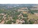Vast aerial landscape showing the house situated amongst lush trees, expansive fields, and neighboring residences at 34211 Blanton Rd, Dade City, FL 33523