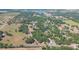 Aerial view showing the land and surrounding area with trees, fields, and a lake in the distance at 34211 Blanton Rd, Dade City, FL 33523