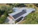 Aerial view of a home with solar panels, manicured landscaping, and mature trees enhancing its curb appeal at 34211 Blanton Rd, Dade City, FL 33523