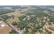 Wide aerial shot showcasing a home nestled among trees, with fields and surrounding residences nearby at 34211 Blanton Rd, Dade City, FL 33523