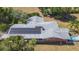 Aerial view of a property featuring solar panels, landscaped surroundings, and a private pool area at 34211 Blanton Rd, Dade City, FL 33523