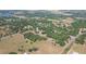 Sprawling aerial view featuring the home nestled in trees, with fields, community, and lake in background at 34211 Blanton Rd, Dade City, FL 33523