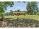Spacious backyard with an array of mature trees and greenery and a view of the home's backside at 34211 Blanton Rd, Dade City, FL 33523