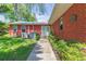 Charming backyard showcasing a brick home with a manicured lawn, landscaping and pathway to the backdoor at 34211 Blanton Rd, Dade City, FL 33523