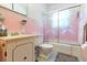 Vintage pink bathroom featuring a sink, toilet, and shower with sliding glass doors at 34211 Blanton Rd, Dade City, FL 33523