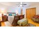 Bedroom with hardwood floors, ceiling fan, wooden sleigh bed, and a plush accent chair at 34211 Blanton Rd, Dade City, FL 33523