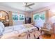 Bright bedroom featuring a quilt bedspread, chair, dresser, and large window at 34211 Blanton Rd, Dade City, FL 33523