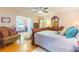 Bright bedroom features a ceiling fan, an ornate dresser with a mirror, and a plush accent chair at 34211 Blanton Rd, Dade City, FL 33523
