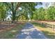 Gated driveway provides privacy and security, lined by lush landscaping and mature trees at 34211 Blanton Rd, Dade City, FL 33523