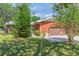 Exterior view of the home featuring a well-maintained lawn, an attached two-car garage and brick siding at 34211 Blanton Rd, Dade City, FL 33523