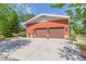 A close exterior of an attached two-car garage showing the concrete driveway and landscaping at 34211 Blanton Rd, Dade City, FL 33523