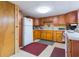 Basement kitchen with wooden cabinets, appliances, and a red rug at 34211 Blanton Rd, Dade City, FL 33523