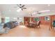 Spacious living room with skylights, ceiling fans, brick accent wall, and wood-look flooring at 34211 Blanton Rd, Dade City, FL 33523