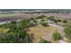 Expansive aerial view showcasing the property's location with mature trees and surrounding farmland at 3515 Bell Farms Dr, Plant City, FL 33566