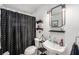 Cozy bathroom featuring black and white shower curtain and industrial-style mirror and lighting at 3515 Bell Farms Dr, Plant City, FL 33566