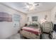 Cozy bedroom with white four-poster bed, natural light, and whitewashed hardwood-style flooring at 3515 Bell Farms Dr, Plant City, FL 33566