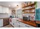 Well-organized kitchen featuring open shelving, farmhouse sink, and butcher block countertops at 3515 Bell Farms Dr, Plant City, FL 33566