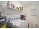 Functional laundry room with washer, dryer, shelving, water heater, and well-lit space at 3515 Bell Farms Dr, Plant City, FL 33566