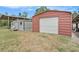 Multiple outbuildings on the property including sheds and a red metal garage for storage at 3515 Bell Farms Dr, Plant City, FL 33566