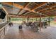 Spacious covered patio with brick pavers, seating, and outdoor entertainment area with wooded backdrop at 3515 Bell Farms Dr, Plant City, FL 33566