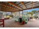 Extended covered patio with brick pavers, outdoor kitchen, sink, grill, and greenhouse area at 3515 Bell Farms Dr, Plant City, FL 33566