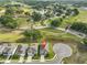 An aerial view of a residential neighborhood with well-maintained green spaces and a nearby lake at 36959 Highland Meadows Ct, Zephyrhills, FL 33542