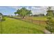 A spacious, green backyard with mature trees and an iron fence around the property at 36959 Highland Meadows Ct, Zephyrhills, FL 33542