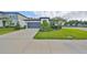 Charming home featuring a well-manicured lawn, gray two-car garage and delightful landscaping at 36959 Highland Meadows Ct, Zephyrhills, FL 33542