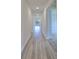 Hallway features modern, wood-look flooring and leads to sunlit living spaces at 36959 Highland Meadows Ct, Zephyrhills, FL 33542