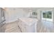 Bright kitchen featuring an island with a white countertop and stainless steel appliances and gray wood flooring at 36959 Highland Meadows Ct, Zephyrhills, FL 33542