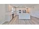 Kitchen with modern stainless steel appliances, white cabinetry, hardwood floors, and a center island at 36959 Highland Meadows Ct, Zephyrhills, FL 33542