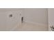 An empty laundry room features tile floors and connections for a washer and dryer at 36959 Highland Meadows Ct, Zephyrhills, FL 33542