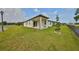 Rear exterior view of house featuring green lawn and covered patio at 36959 Highland Meadows Ct, Zephyrhills, FL 33542