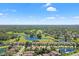 Aerial view showcases the neighborhood, golf course, with a lake, and lush greenery, offering a scenic landscape at 3964 Silk Oak Ln, Palm Harbor, FL 34685