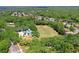 Aerial view of neighborhood showcasing a soccer field, tennis courts and a dense tree canopy, all close to residential area at 3964 Silk Oak Ln, Palm Harbor, FL 34685