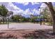 Outdoor basketball court with multiple hoops and a covered seating area for players and spectators at 3964 Silk Oak Ln, Palm Harbor, FL 34685
